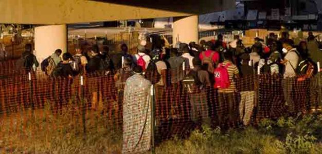 Migrants_many_of_them_Haitians_await_buses